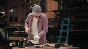 Confident carpenter man sawing wooden board with hand saw inside workshop. Wood processing inside timber workshop. DIY woodworking, handmade furniture, home improvement and craftsmanship concept.
 - Powered by Shutterstock - Get 15% off with code: PIKWIZARD15