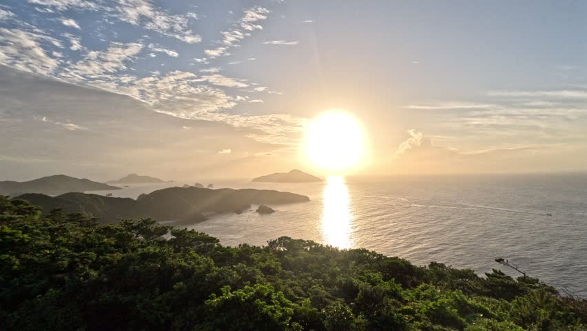 A scene of watching the sun set gently under a clear sky.