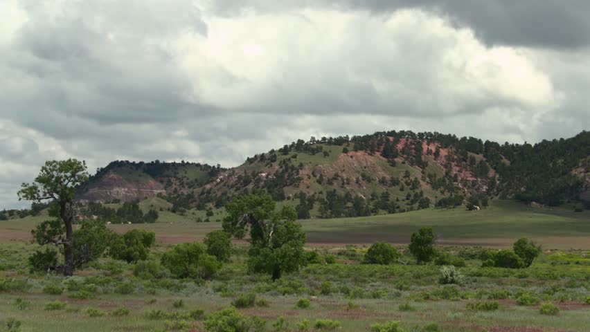 Nebraska, USA panoramic view of rolling green hills, trees, and dramatic overcast sky