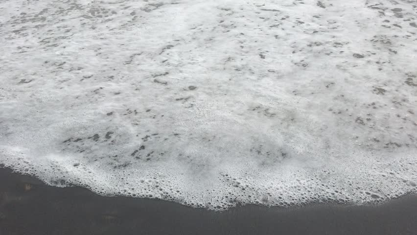 Waves crashing on a unique black sand beach in Varkala, India.