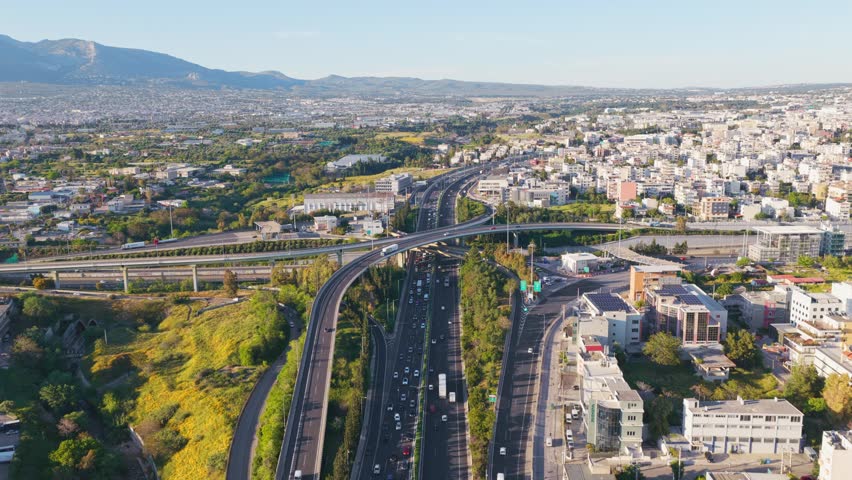 Breathtaking aerial footage capturing the intricate network of a bustling highway interchange with vehicles flowing through the city, showcasing modern infrastructure and urban transportation