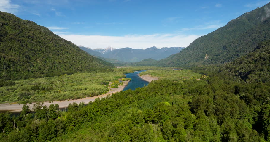 Petrohué River flowing through lush green valley in Vicente Pérez Rosales National Park, Patagonia, Chile. Aerial forward, panoramic view, copy space
