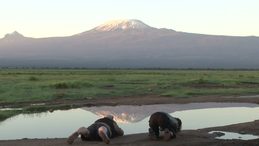 photographers capturing a shot of reflection of mount kilimanjaro