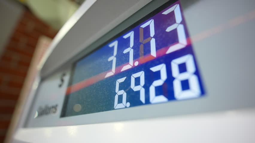 Close up view of Gas station pump display showing fuel price and gallons during car gas refueling process.