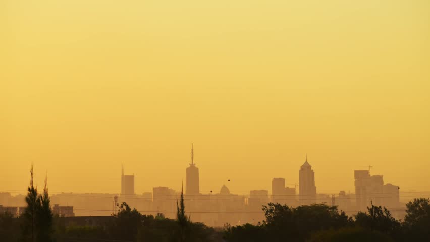 Nairobi city skyline timelapse panorama sunset over Kenya Africa. Cinematic golden hour over CBD skyscrapers and urban landscape. African metropolitan horizon at dusk, hazy evening atmosphere.