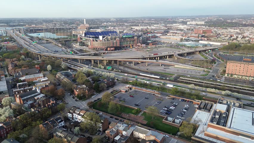 Stadium highway sport complex near Russell St sits beside elevated ramps, parking lots, residential blocks extending downtown. Concrete spans define broad urban textures Baltimore, MD. USA