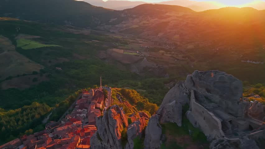 Aerial view of Castelmezzano village at sunset in Potenza, Basilicata, Italy, picturesque settlement nestled among the Dolomiti Lucane mountains with historic stone houses and dramatic rocky landscape