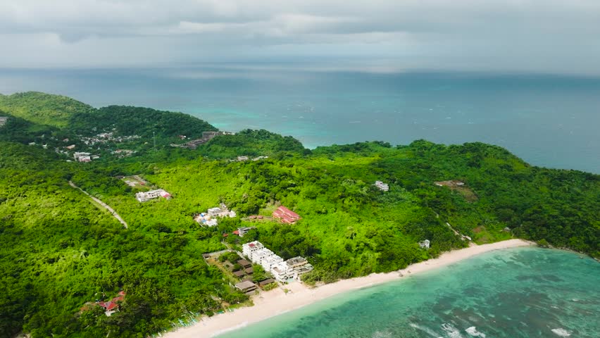 Drone view of beach resorts with ocean waves and white sand. Ilig Iligan Beach. Boracay, Philippines.