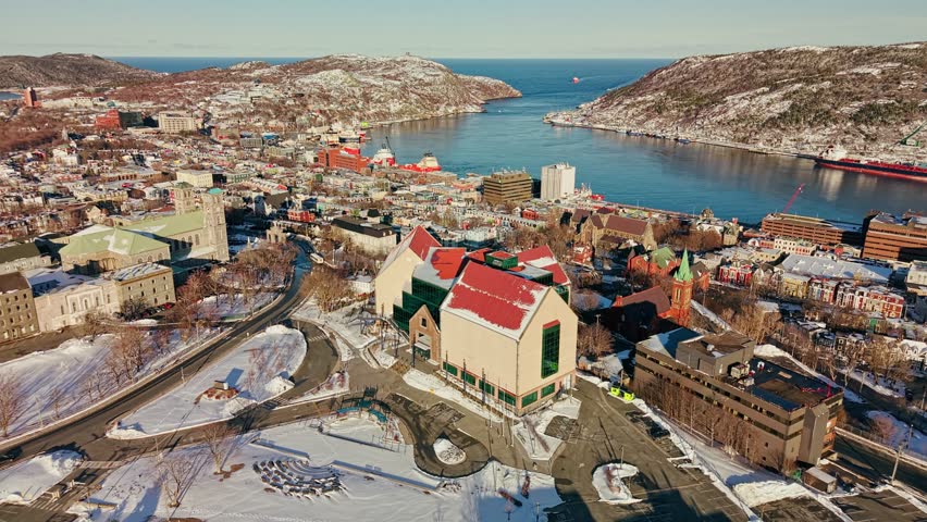 Aerial drone view of The Rooms in St Johns with panoramic harbor Signal Hill tanker ships downtown core and snow covered hills in Newfoundland winter
