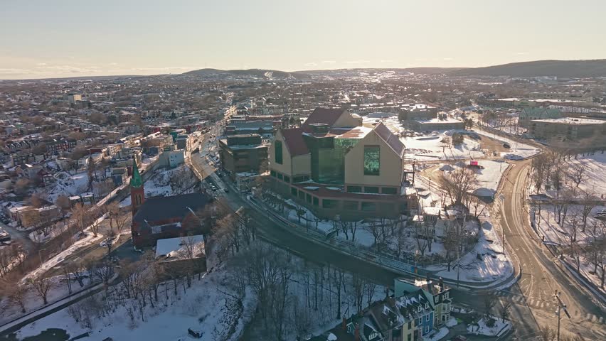 Aerial drone shot of The Rooms cultural center in St Johns Newfoundland surrounded by snow covered city and church steeple in winter
