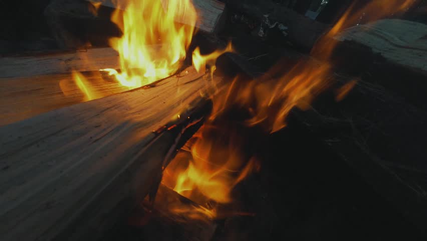 Adirondack Mountain, New York State. A closeup shot of a fire burning in a wooden structure, possibly a campfire. The flames are bright orange and yellow.