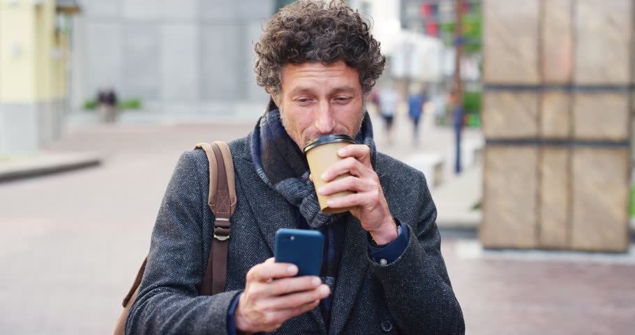 Coffee, city and man with phone for travel, communication or lecturer checking email in street. Professional, drink and mature professor with online scroll, reading and outdoor with academic app