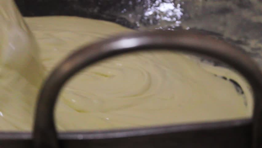 Detail of a cheese mixture being melted on a flat surface to produce the typical and delicious Colombian Quesillo inside a factory in Yaguara, Huila, Colombia. Concept of artisanal food