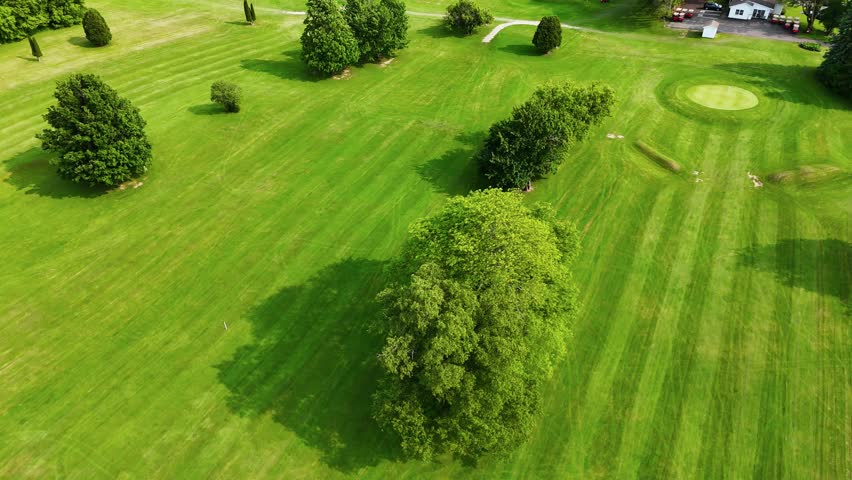 Lyndon Golf Course. Passing over a field as people golf off in the distance.