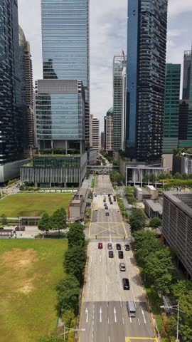 Singapore Central Business District daytime, view of downtown skyscrapers, modern glass towers and city street in the financial district of Asia. Vertical 4K aerial drone footage.