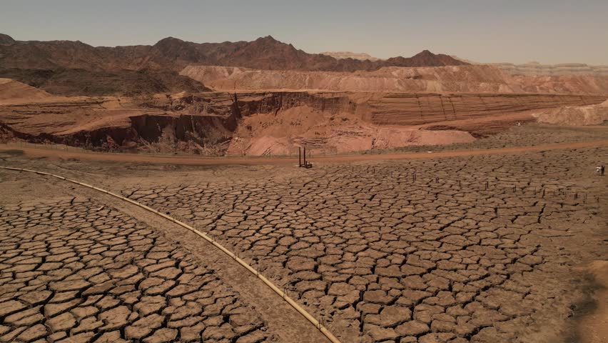 Aerial View of Cracked Desert Ground and Red Cliffs in Timna Israel