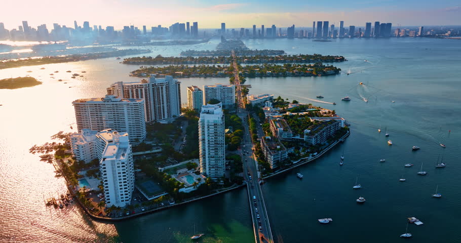 Flight over the Biscayne Bay waterscape with numerous vessels. Aerial perspective on the Brickell Key neighborhood of Miami, Florida, USA.