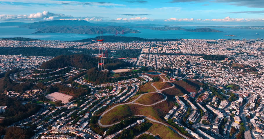 Vast urban landscape of modern San Francisco, California, USA. Drone footage around the green hills with Sutro Tower on.