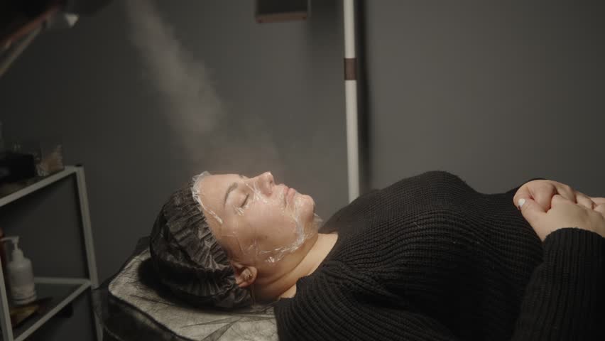Side view of woman undergoing professional facial steaming