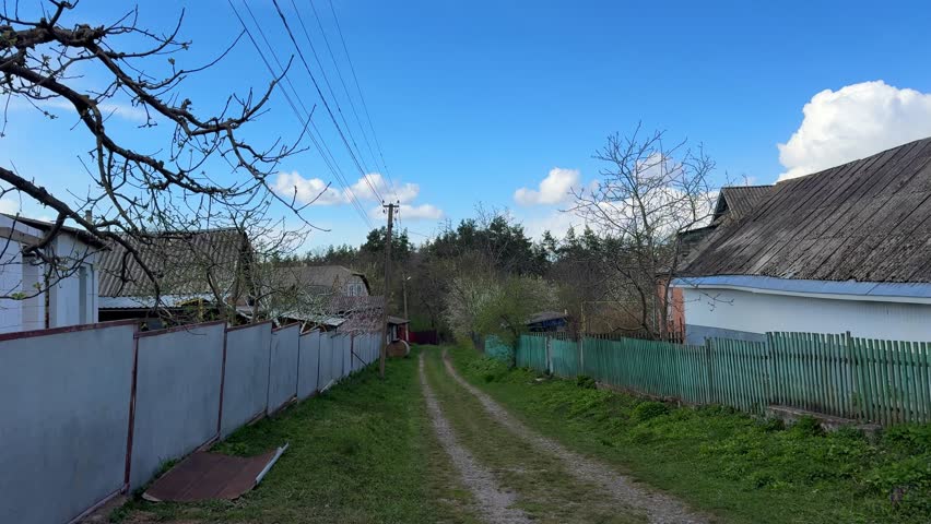 rural dirt road with wooden fences on both sides simple countryside scene spring 