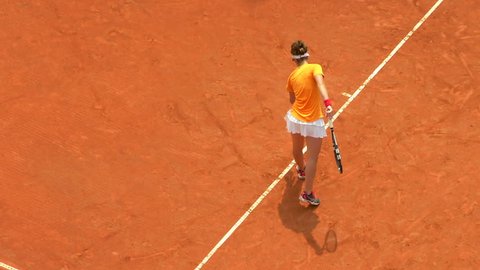 Girl play tennis outdoor on orange clay tennis court