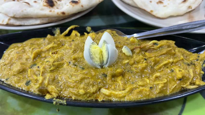 Tandoori roti and chicken bharta served in a roadside dhaba in Kolkata; professional food photography of traditional Indian flatbread and shredded chicken curry in West Bengal.