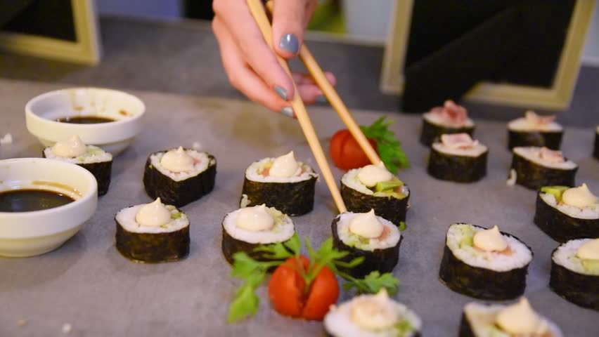 Japanese Sushi and Sashimi Assortment Food Platter with Hand Eating