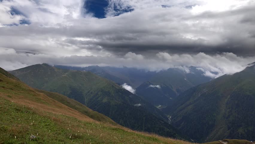 Lower slopes of Peru mountain ranges showing vast Andean landscape beneath cloud formations. Layered highlands create broad scenery, outdoor travel appeal, natural depth, open atmosphere. The Peruvian Andes include high cordilleras, clouded slopes, deep valleys, plateaus, and rugged terrain, adding strong geography terms for South American mountain wilderness.