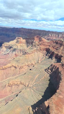 Amazing aerial view from a helicopter window flying over the majestic grand canyon national park and the colorado river on a sunny day, showcasing the vast and dramatic landscape of arizona