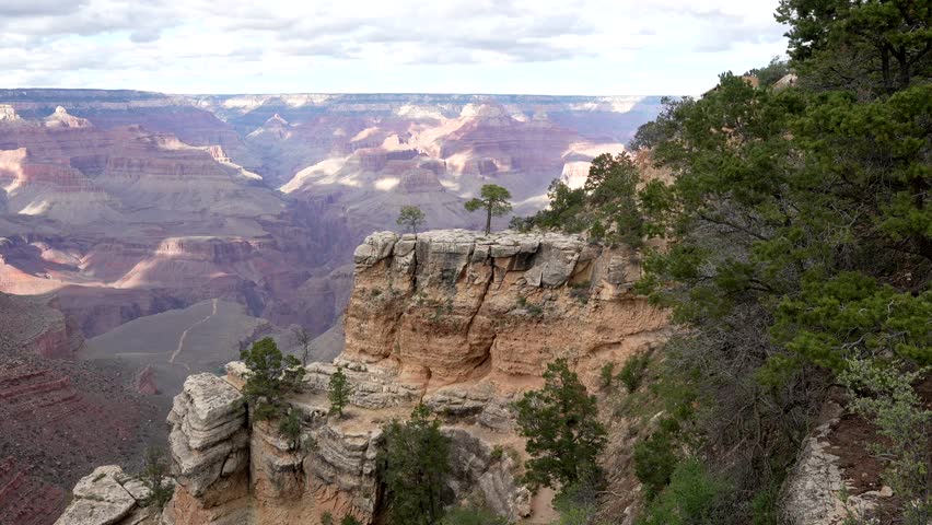 Beautiful panoramic view from the south rim of the grand canyon national park in arizona, showing the immense gorge with its colorful rock layers and shadows cast by passing clouds