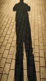 Vertical cinematic pan of person's shadow walking on pavement, golden hour sunlight, mysterious silhouette of a traveler, candid daily life style. Professional 4K vertical footage using Pixel 9 cinematic stabilizer, perfect for vlogs, motivational social media stories, and urban lifestyle branding. - Powered by Shutterstock - Get 15% off with code: PIKWIZARD15
