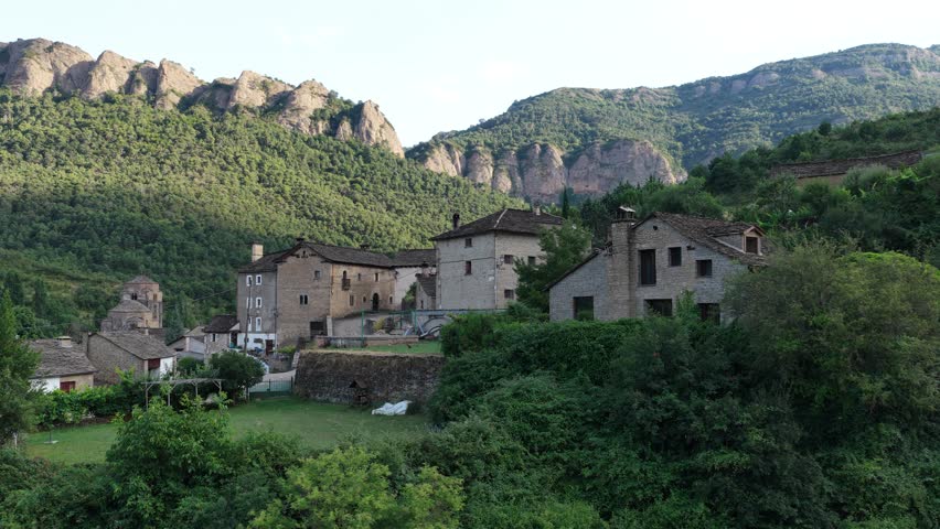 Beautiful medieval village with stone houses nestled in a lush green valley in the mountains of the Pyrenees, a tranquil and scenic place
