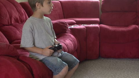 Young boy playing video games stops