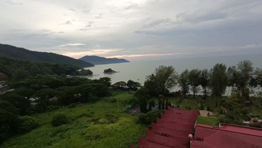 capturing the vibrant architectural beauty of Ferringhi Villas surrounded by dense tropical hills and the tranquil coast of Penang, Malaysia.