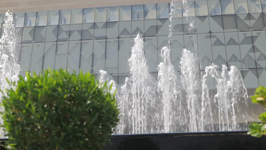 Modern Water Fountain Jets Spraying in Front of Contemporary Building Facade in Saudi Arabia