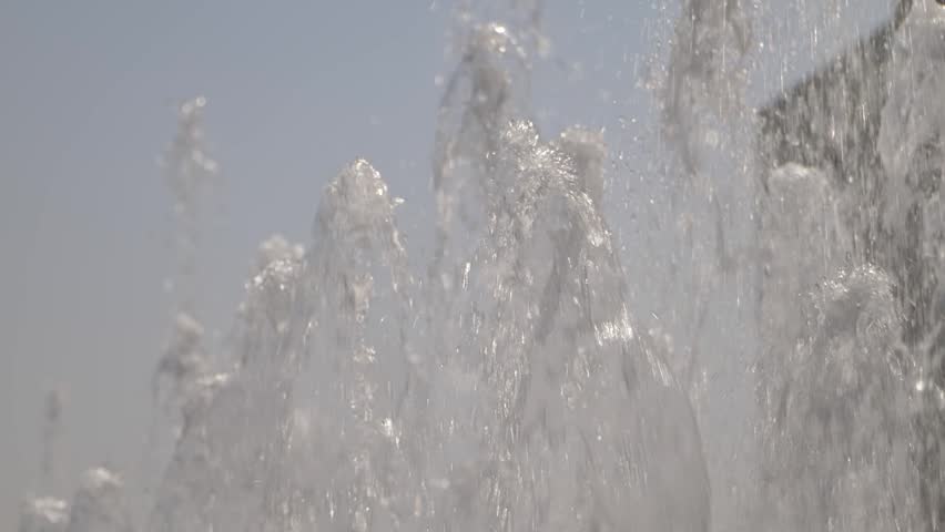 Close up of multiple water jets spraying upwards from a modern outdoor fountain in Saudi Arabia