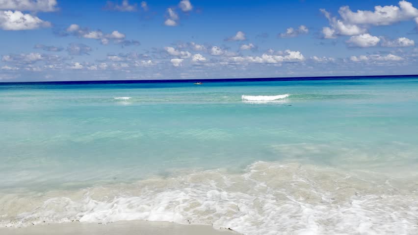 Beautiful caribbean beach with blue sky. Holiday beach park video without a tourist area. Wavy waves coming onto the sandy beach. Summer landscape. Varadero, Cuba