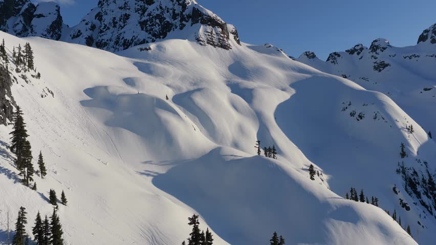 A Skier Descends a Majestic Snow-Covered Mountain Slope in British Columbia, Canada