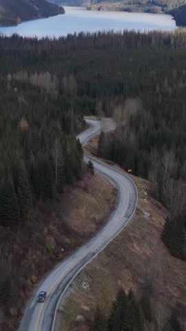Scenic Drive Through Winding Mountain Road and Forest Towards a Serene Lake in British Columbia, Canada