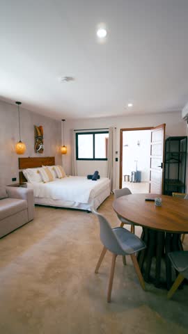 Spacious and elegant hotel room with a comfortable bed, dining table, and contemporary decor. A bright and inviting vacation rental