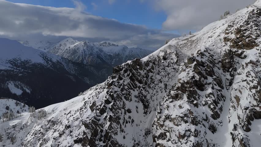 Majestic Snowy Mountain Peaks And Rocky Ridge In British Columbia, Canada, Under A Dramatic Sky