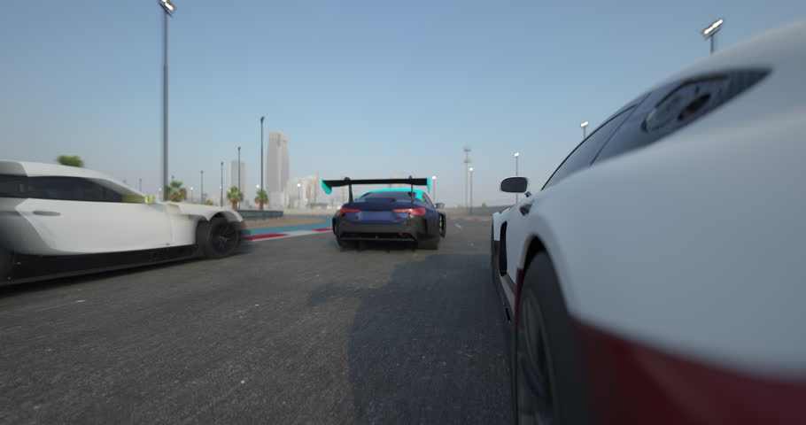 Three race cars driving side by side on a racetrack during daytime, close view with motion blur emphasizing speed, clear sky and track details visible