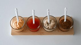 Video close up showing different sauce textures from smooth mustard to chunky grain mustard in glass bowls, condiment detail for food styling and culinary product editorial concept - Powered by Shutterstock - Get 15% off with code: PIKWIZARD15