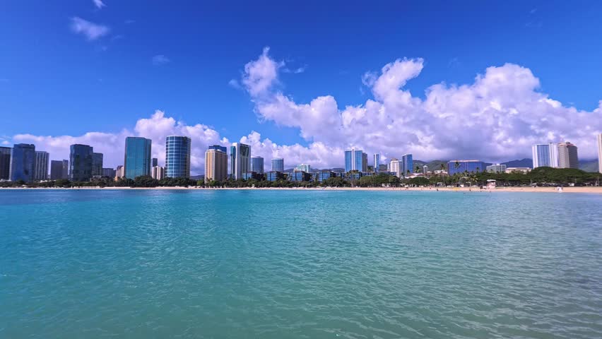 Honolulu, USA - View of the buildings and coastline of the Waikiki neighborhood. Hotels and resorts line the beach, while the Pacific Ocean extends to the horizon.