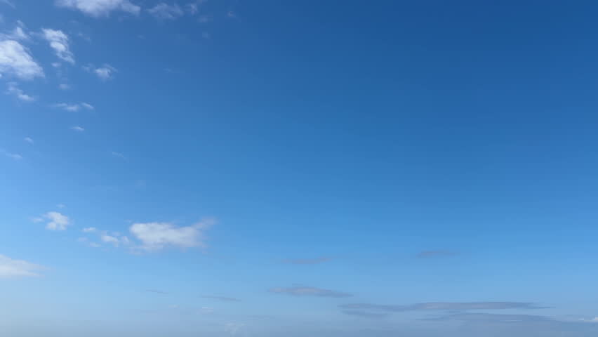 Clear blue sky with soft drifting clouds in a peaceful atmosphere