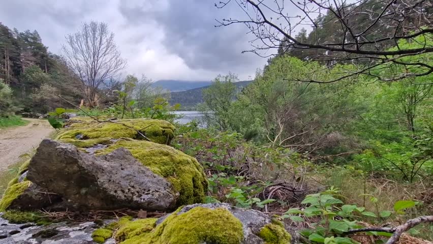 Stunning natural landscape with a lake and mountains under a dramatic cloudy sky