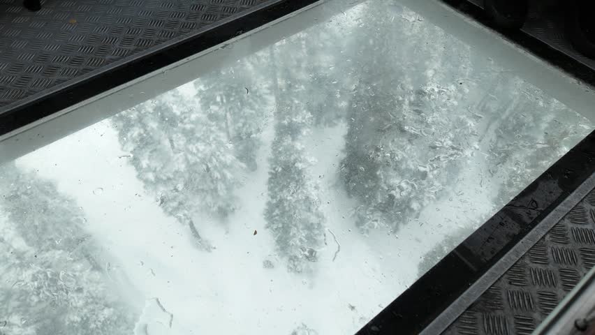 Passenger POV riding the scenic "Peak 2 Peak" glass bottom gondola in Whistler Mountain Ski Resort, BC, Canada.