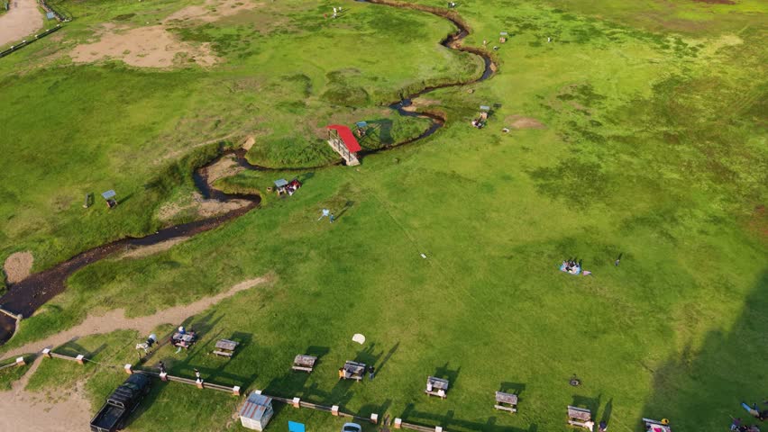 Wide aerial of stream connecting to lake in forest environment