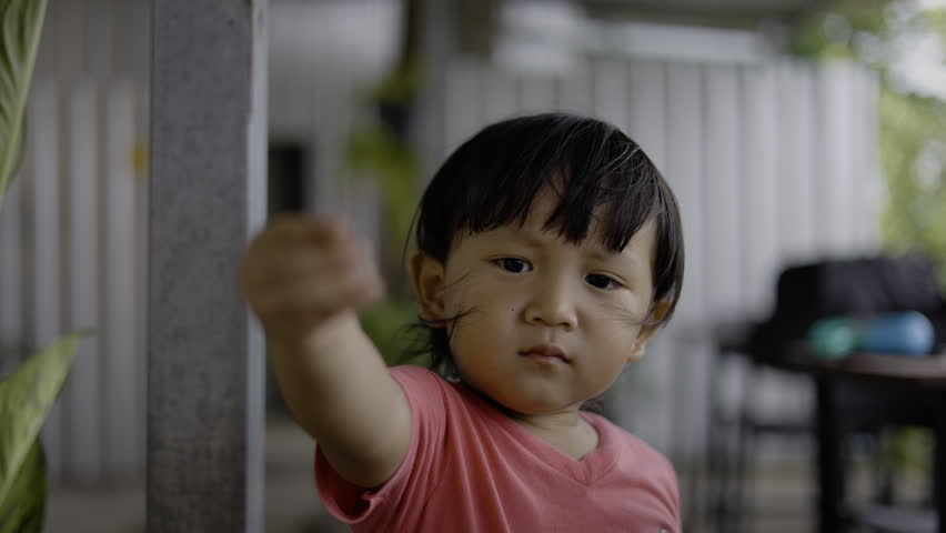 Happy Toddler Enjoying A Healthy Orange Snack. Asian little boy sitting and eating fresh orange slices at home, perfect for healthy child nutrition and family lifestyle themes.