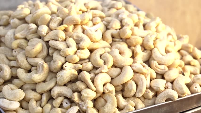 Abundant pile of raw, unsalted cashew nuts in a tray, healthy snack a detailed close up shot reveals large quantity
